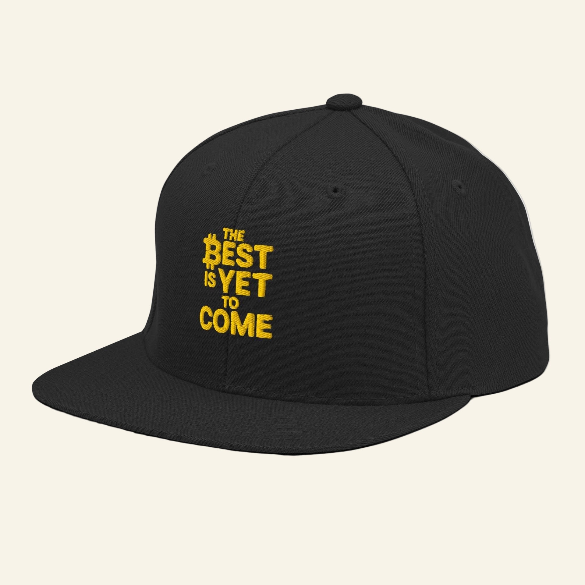 Black cap with yellow text 'The Best is Yet to Come' on a white background