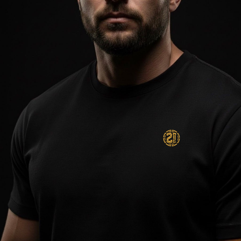 Man wearing a black t-shirt with a gold logo on a black background