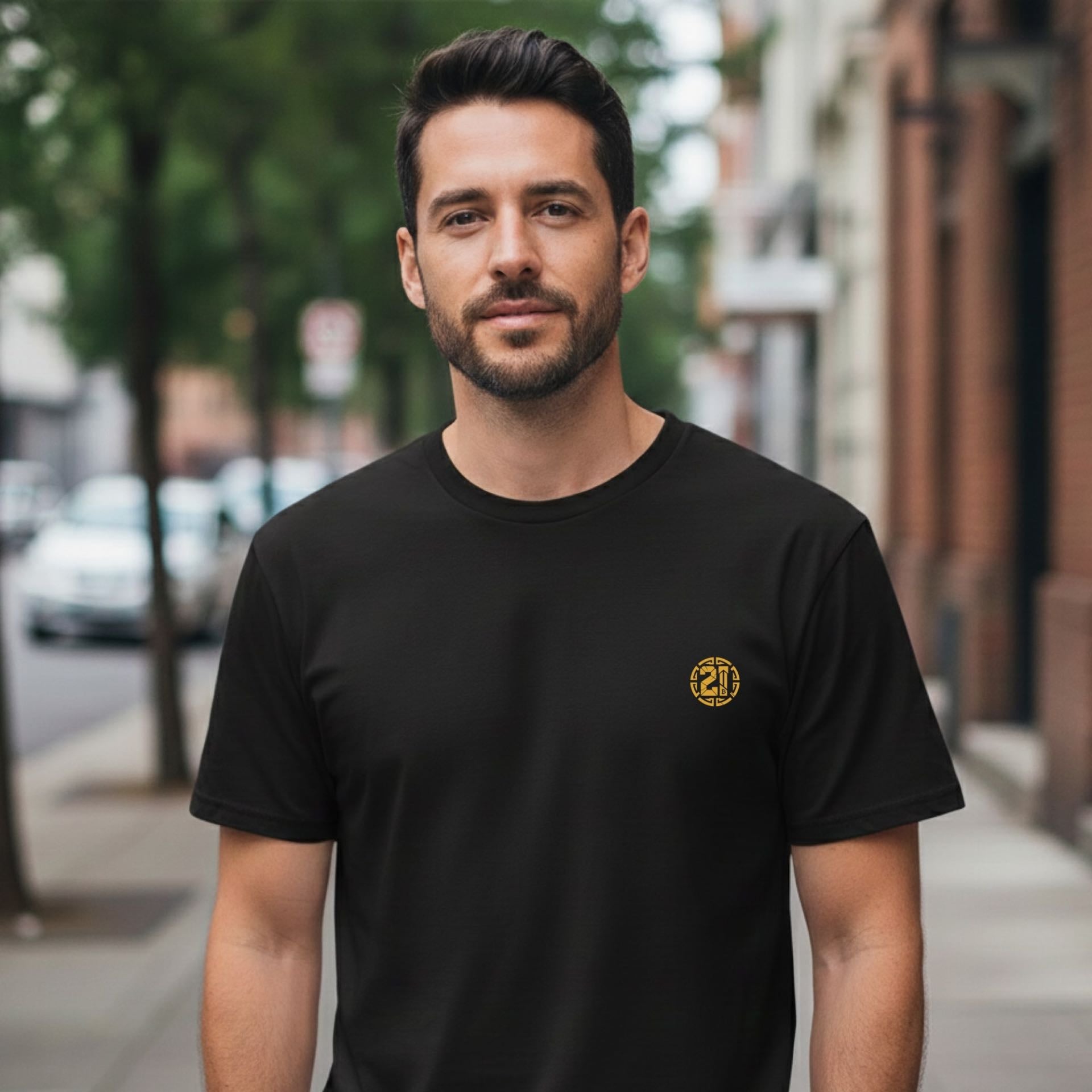Man wearing a black t-shirt with a yellow logo on a city street