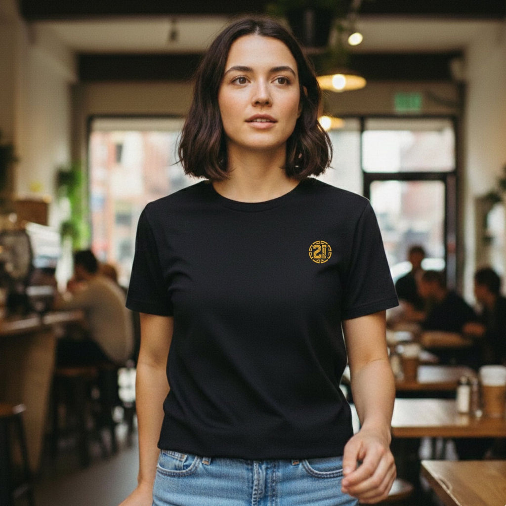 Woman wearing a black t-shirt with a yellow logo in a casual setting